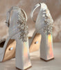 Zapatillas de novia con un tacón ancho y una correa gruesa, decoradas con cristal austriaco y perla bordada en su parte delantera y trasera.