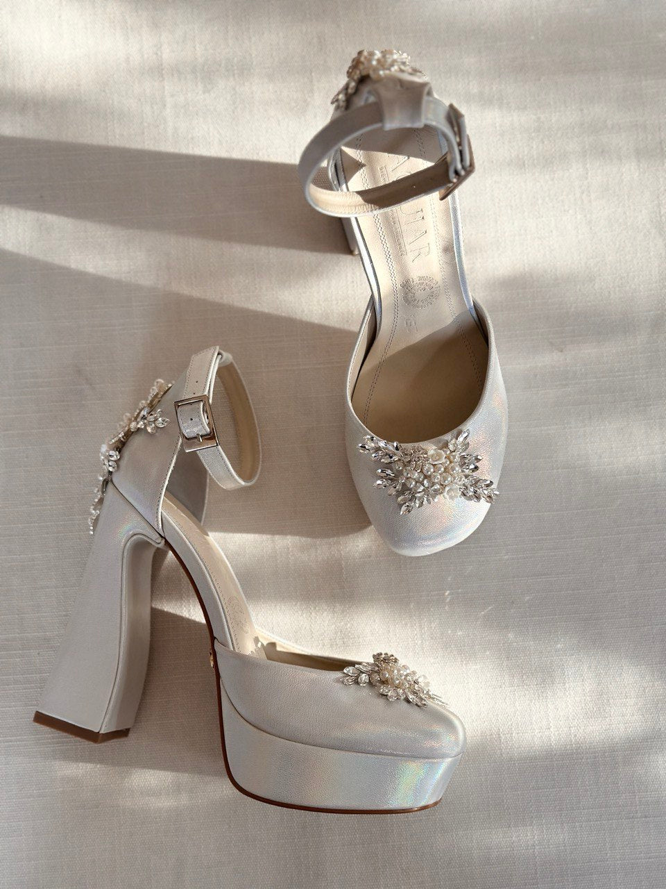 Zapatillas de novia con un tacón ancho y una correa gruesa, decoradas con cristal austriaco y perla bordada en su parte delantera y trasera.