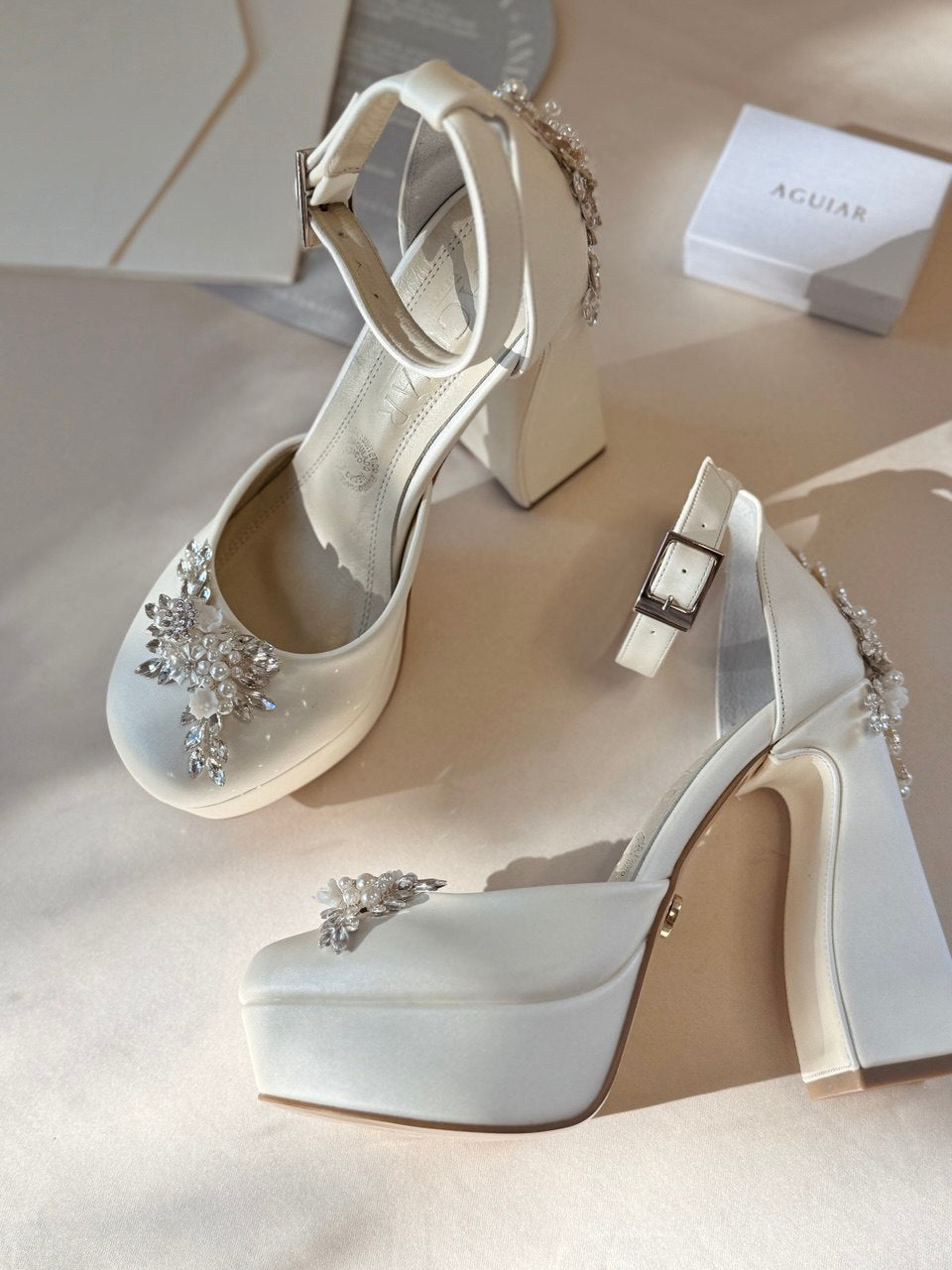 Zapatillas de novia con un tacón ancho y una correa gruesa, decoradas con cristal austriaco y perla bordada en su parte delantera y trasera.