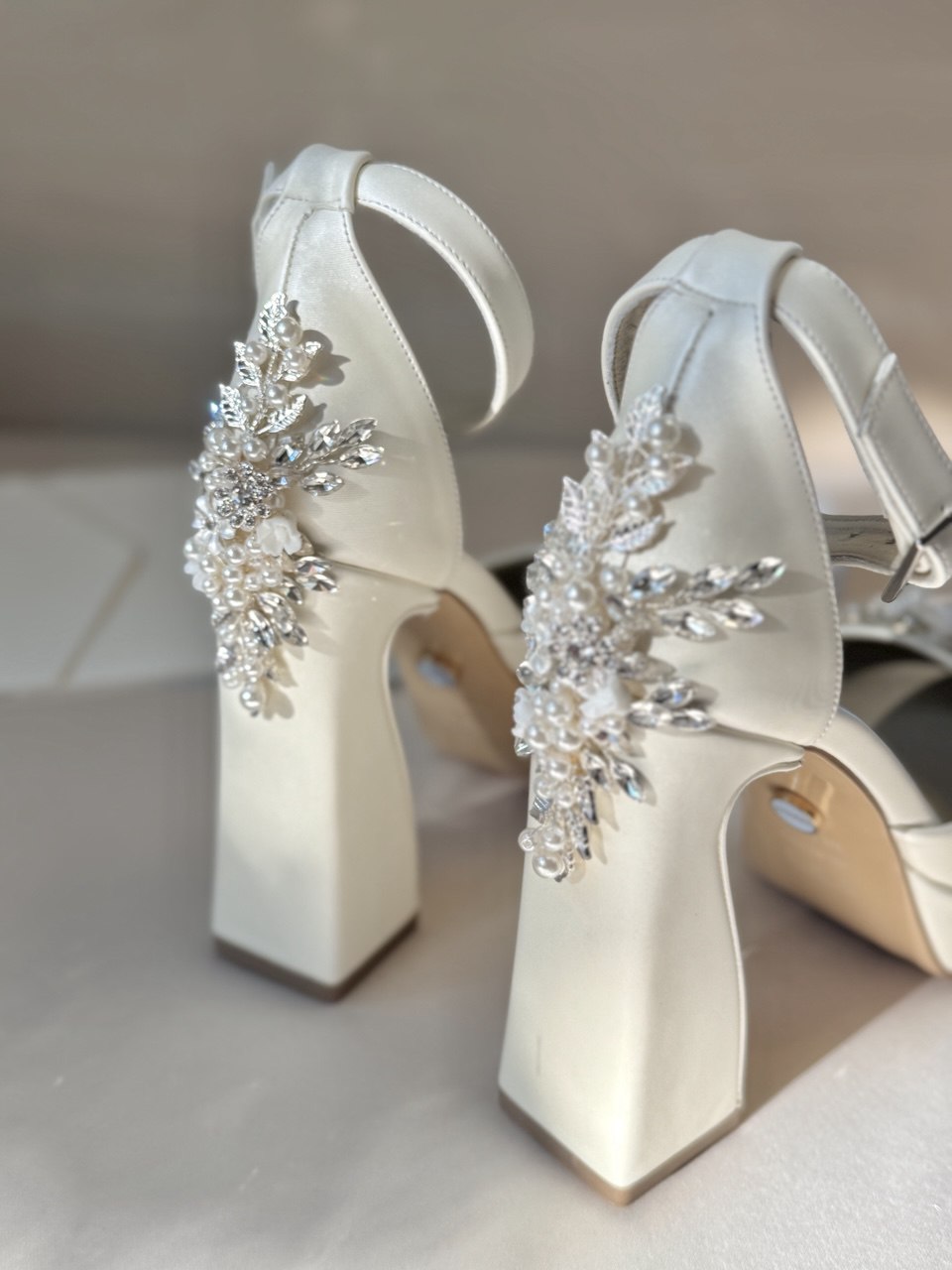 Zapatillas de novia con un tacón ancho y una correa gruesa, decoradas con cristal austriaco y perla bordada en su parte delantera y trasera.