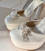 Zapatillas de novia con un tacón ancho y una correa gruesa, decoradas con cristal austriaco y perla bordada en su parte delantera y trasera.