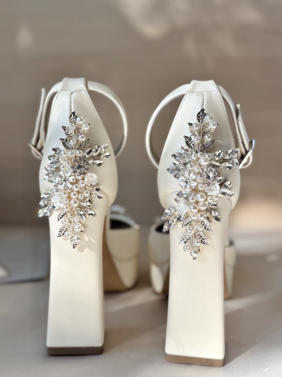 Zapatillas de novia con un tacón ancho y una correa gruesa, decoradas con cristal austriaco y perla bordada en su parte delantera y trasera.