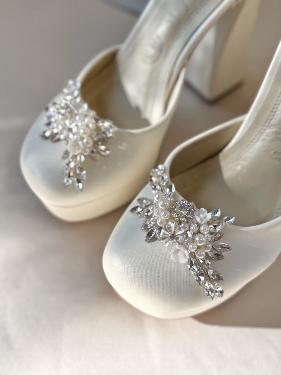 Zapatillas de novia con un tacón ancho y una correa gruesa, decoradas con cristal austriaco y perla bordada en su parte delantera y trasera.
