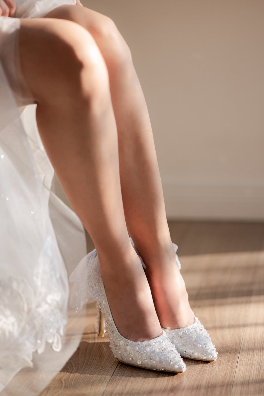 Stiletto de novia de tacón delgado con textil brilloso, lleva cristal austriaco, perla y aplicacion de moño en la parte de atras 