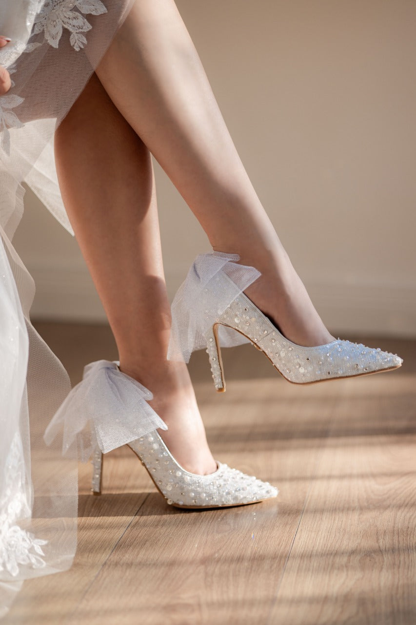 Stiletto de novia de tacón delgado con textil brilloso, lleva cristal austriaco, perla y aplicacion de moño en la parte de atras 
