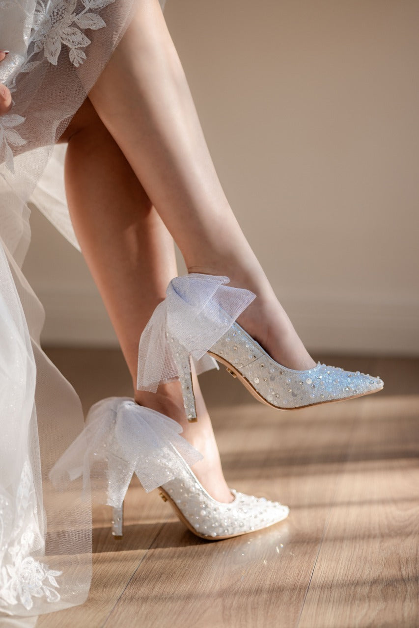 Stiletto de novia de tacón delgado con textil brilloso, lleva cristal austriaco, perla y aplicacion de moño en la parte de atras 