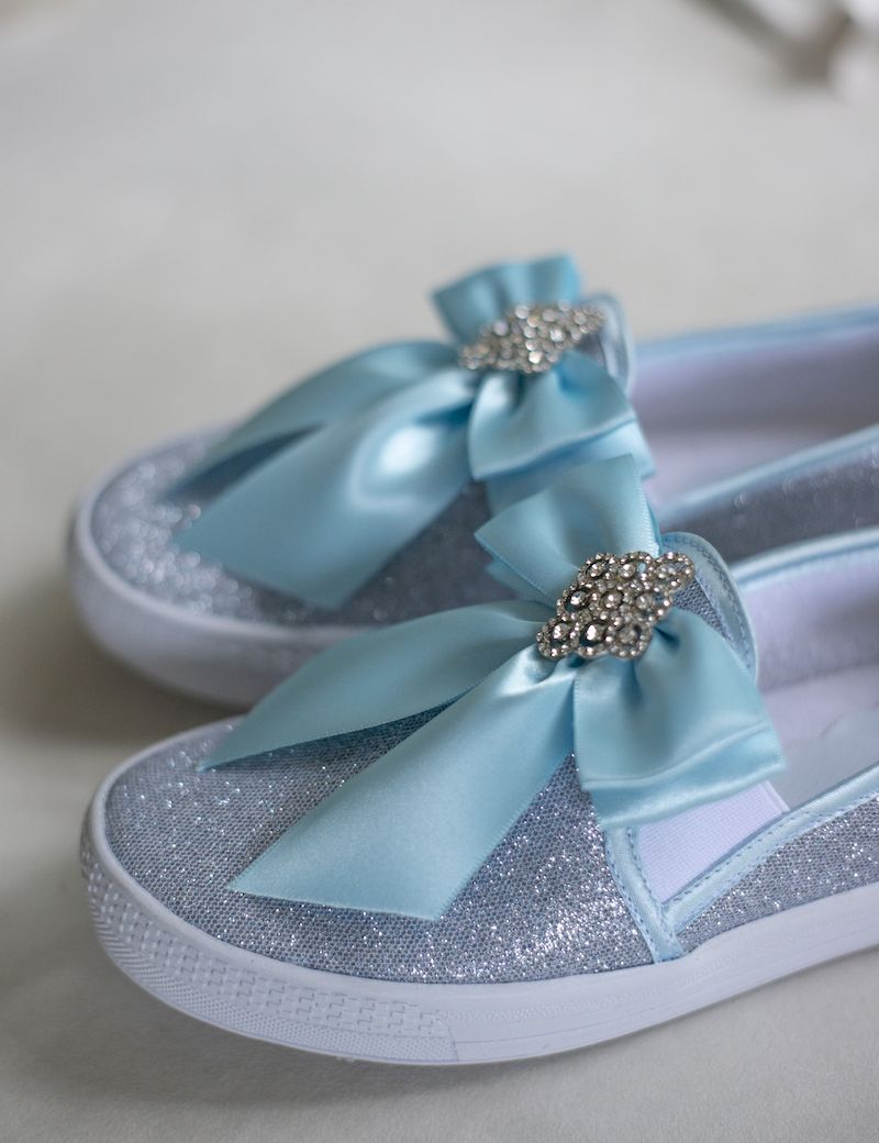Sneakers de piso con moño de textil y aplique de pedrería azul